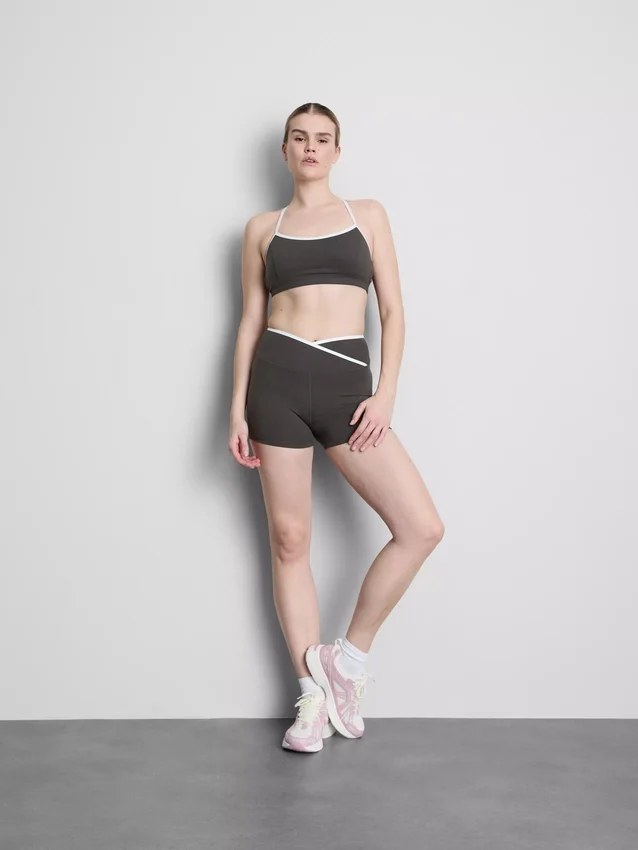 Aktives Crop-Top mit kontrastfarbener Paspelierung und gekreuztem Rücken