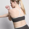 Aktives Crop-Top mit kontrastfarbener Paspelierung und gekreuztem Rücken