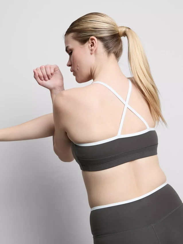 Aktives Crop-Top mit kontrastfarbener Paspelierung und gekreuztem Rücken