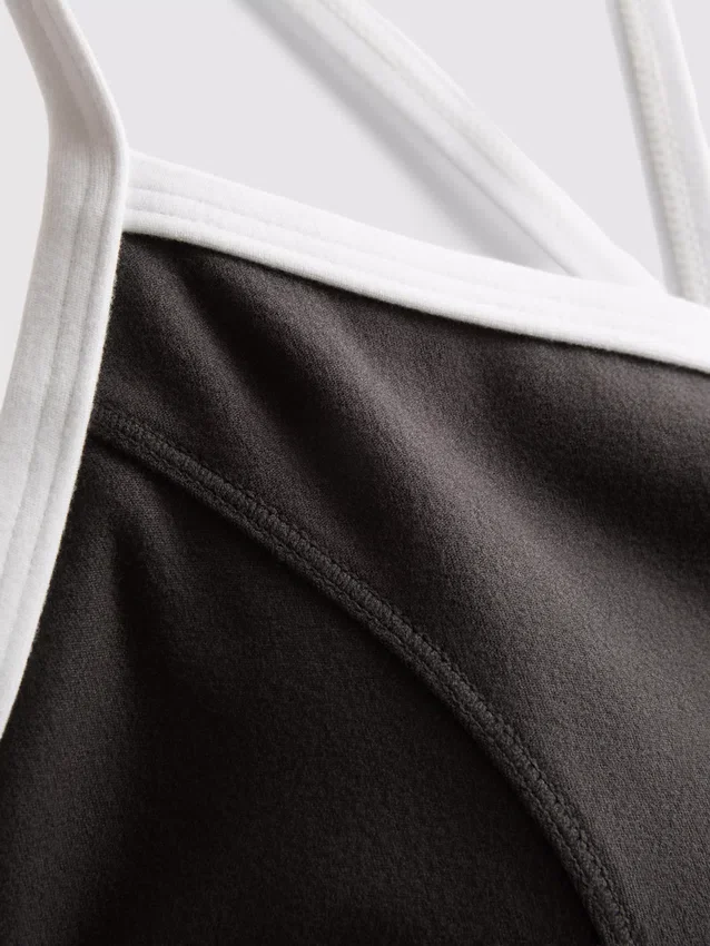 Aktives Crop-Top mit kontrastfarbener Paspelierung und gekreuztem Rücken