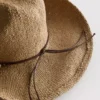 Cowboyhut aus Stroh mit Besatz